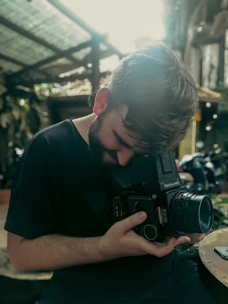 Happy man is looking through viewfinder at medium format camera