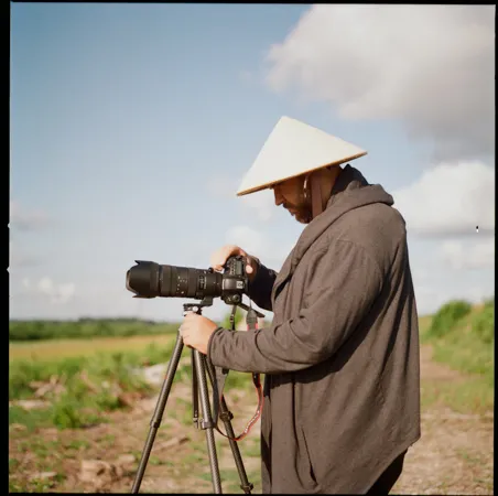 Man in Vietnamese traditional hat taking photo